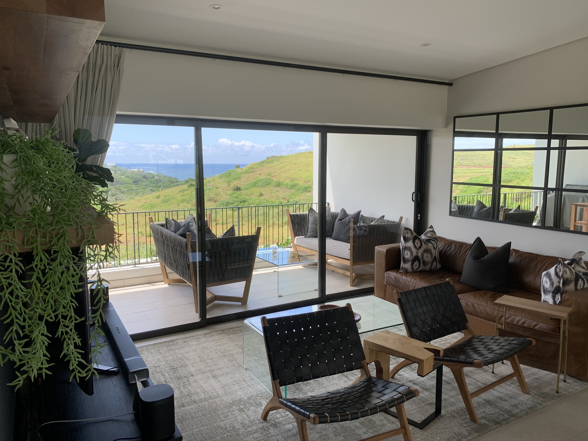 Aluminium sliding door design with glass panels, opening to a covered patio in a modern residential setting.