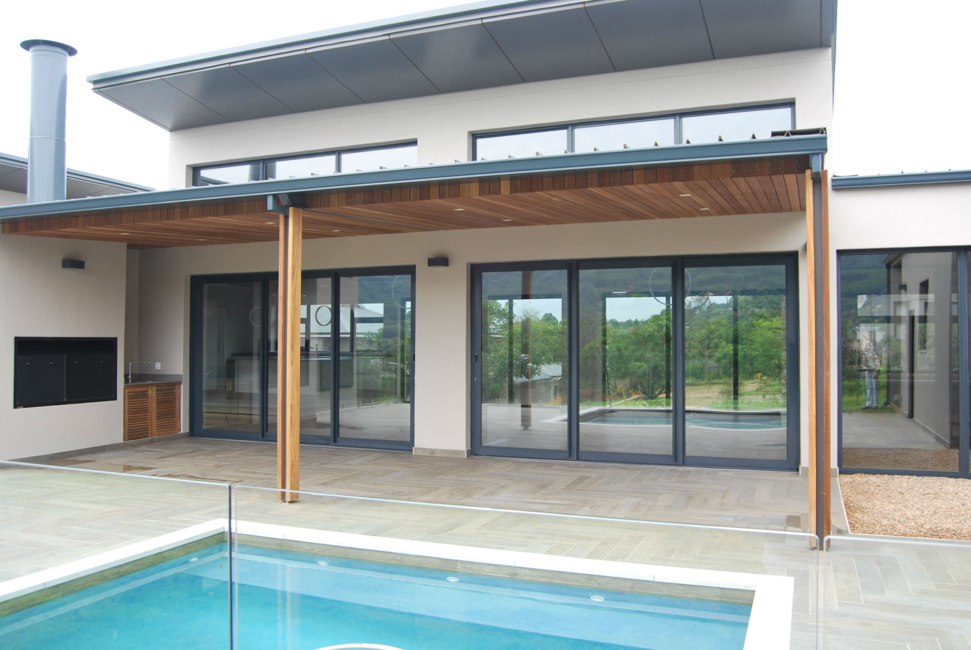 3-pane-palace-door-w1920 Aluminium sliding door design with glass panels, opening to a covered patio in a modern residential setting.