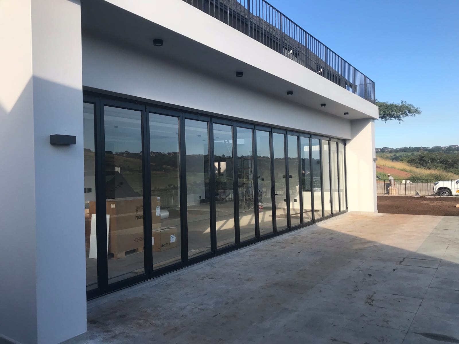 Aluminium folding stacking doors fully opened to create seamless indoor-outdoor flow in a modern residential space.