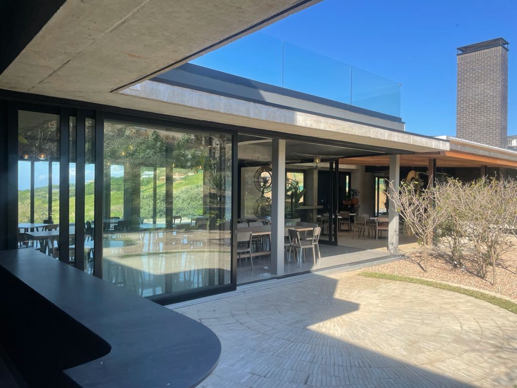 Aluminium sliding door design with glass panels, opening to a covered patio in a modern residential setting.