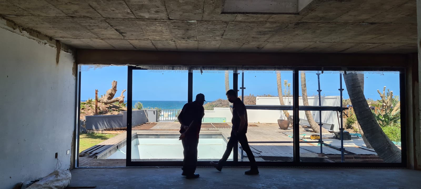 Aluminium sliding door design with glass panels, opening to a covered patio in a modern residential setting.