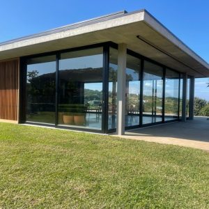 Sleek modern home with aluminium sliding doors and floor-to-ceiling glass offering open views and natural light.