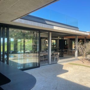 Aluminium sliding door design with glass panels, opening to a covered patio in a modern residential setting.